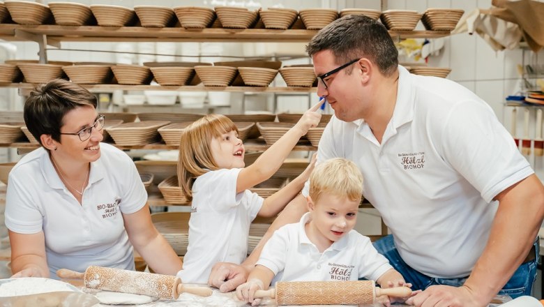 Biohof Hölzl, © Mario Hölzl Familie in einer Bäckerei, die zusammen Teig ausrollt.