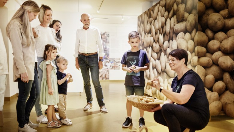 Gruppe von Menschen in einem Museum mit Kartoffelthema.